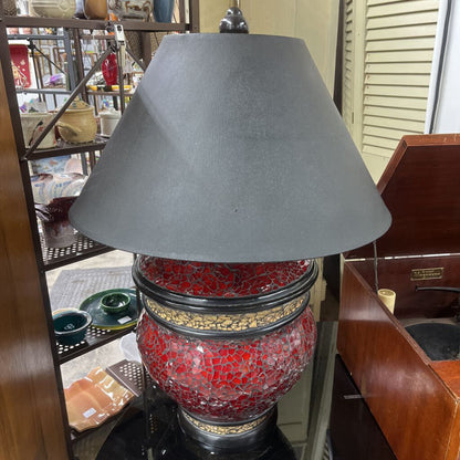 TABLE LAMP FEATURES A RED MOSAIC-TILED BASE, AND A CONICAL BLACK FABRIC LAMP SHADE